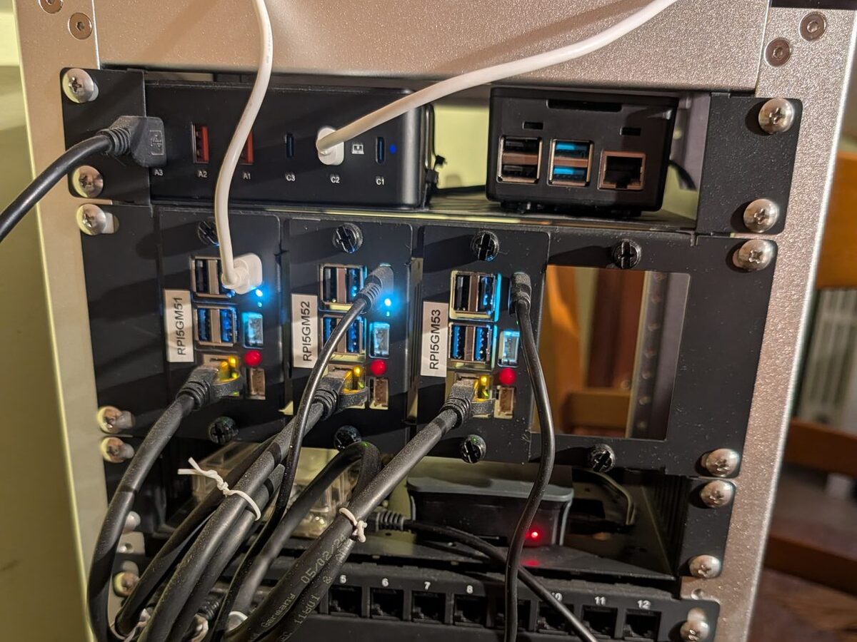 Il rack del cluster: tre nodi Raspberry Pi&nbsp;5 in alloggiamenti separati, collegati allo switch sottostante